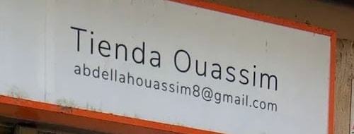 El rètol blanc de la façana amb el nom «Tienda Ouassim» i el correu de la botiga