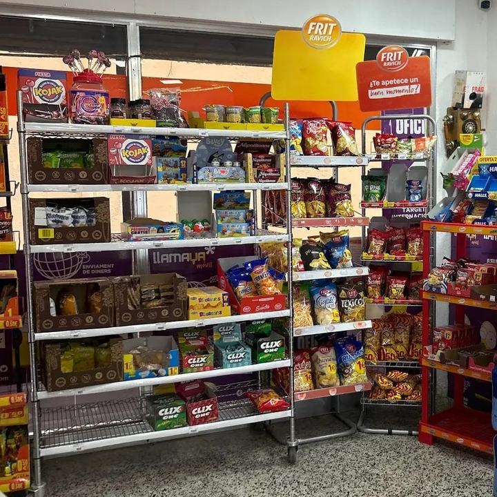 Prestatgeries de Tienda Ouassim amb bosses de patates, snacks, xiclets i caramels